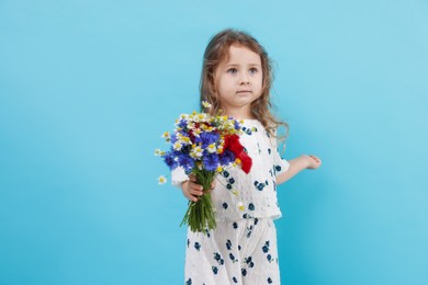 Photo of Cute little girl with bouquet of beautiful flowers on light blue background