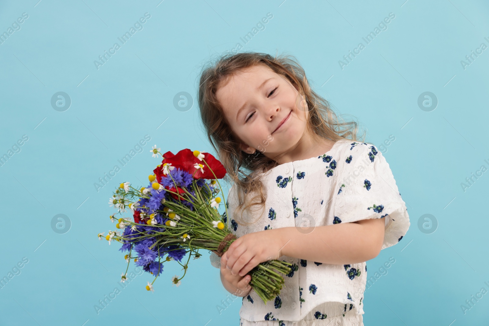 Cute little girl with bouquet of beautiful flowers on light blue background Photo of Cute little girl with bouquet of beautiful flowers on light blue background