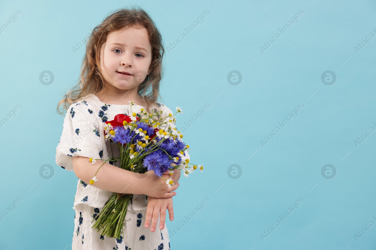 Cute little girl with bouquet of beautiful flowers on light blue background, space for text Photo of Cute little girl with bouquet of beautiful flowers on light blue background, space for text