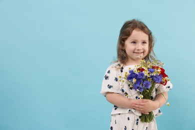 Photo of Cute little girl with bouquet of beautiful flowers on light blue background, space for text