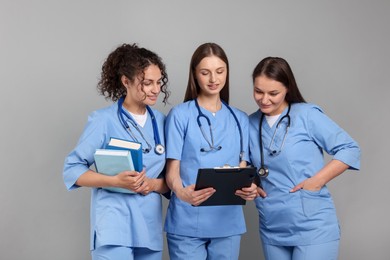 Photo of Group of medical students on light grey background. Space for text