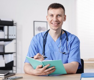 Photo of Medical students in uniforms studying at desks indoors, selective focus