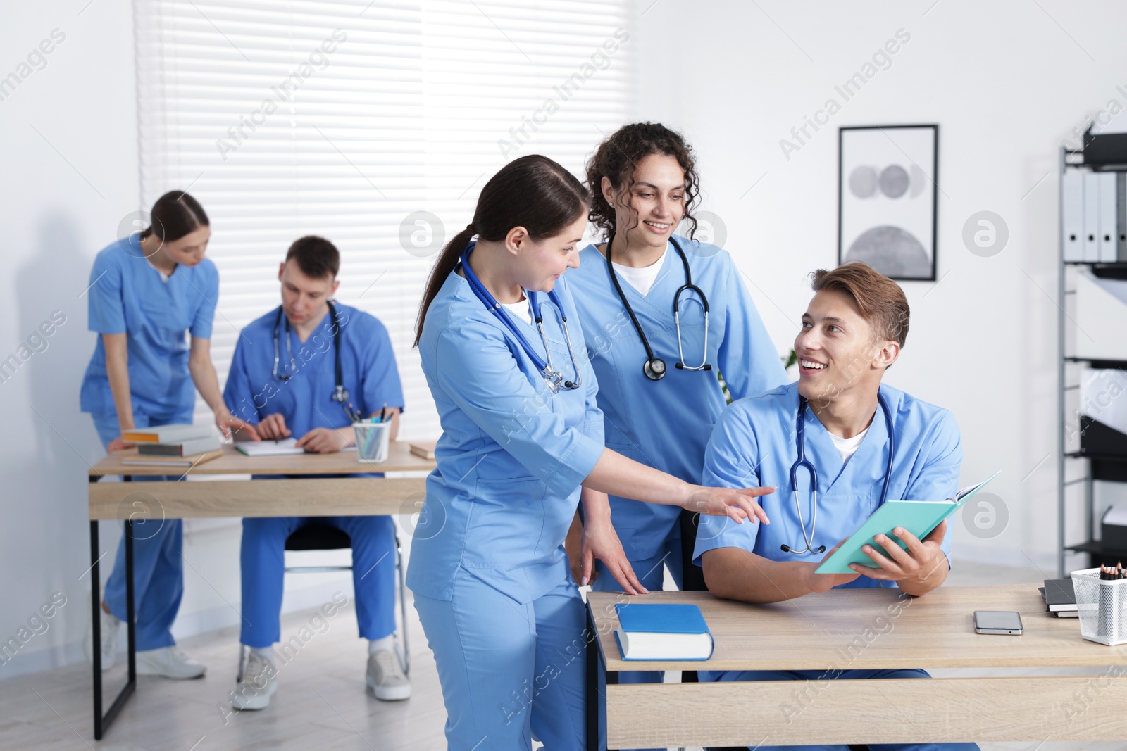Medical students in uniforms studying together at university Photo of Medical students in uniforms studying together at university