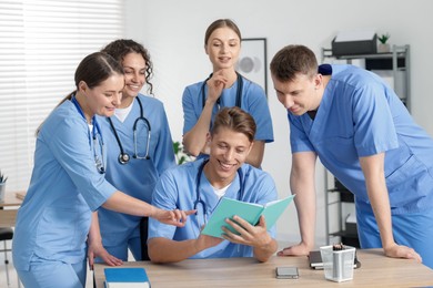 Photo of Medical students in uniforms studying together at university