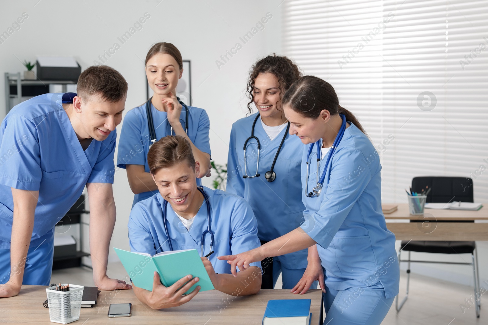 Photo of Medical students in uniforms studying together at university