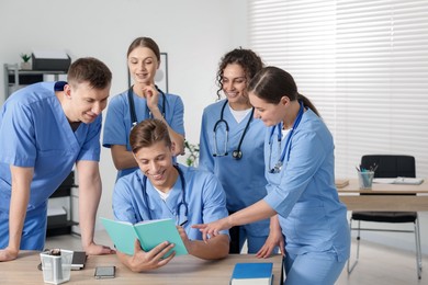 Photo of Medical students in uniforms studying together at university