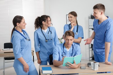 Photo of Medical students in uniforms studying together at university