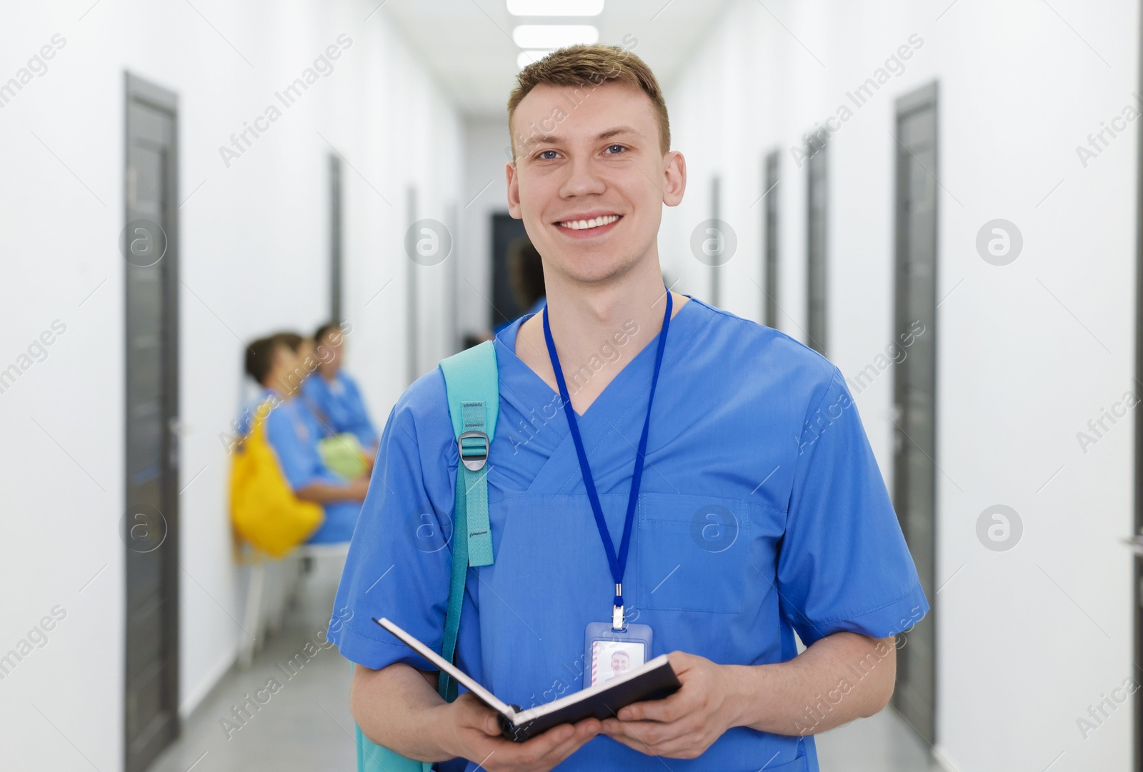 Medical student in uniform with backpack and notebook at university, selective focus Photo of Medical student in uniform with backpack and notebook at university, selective focus