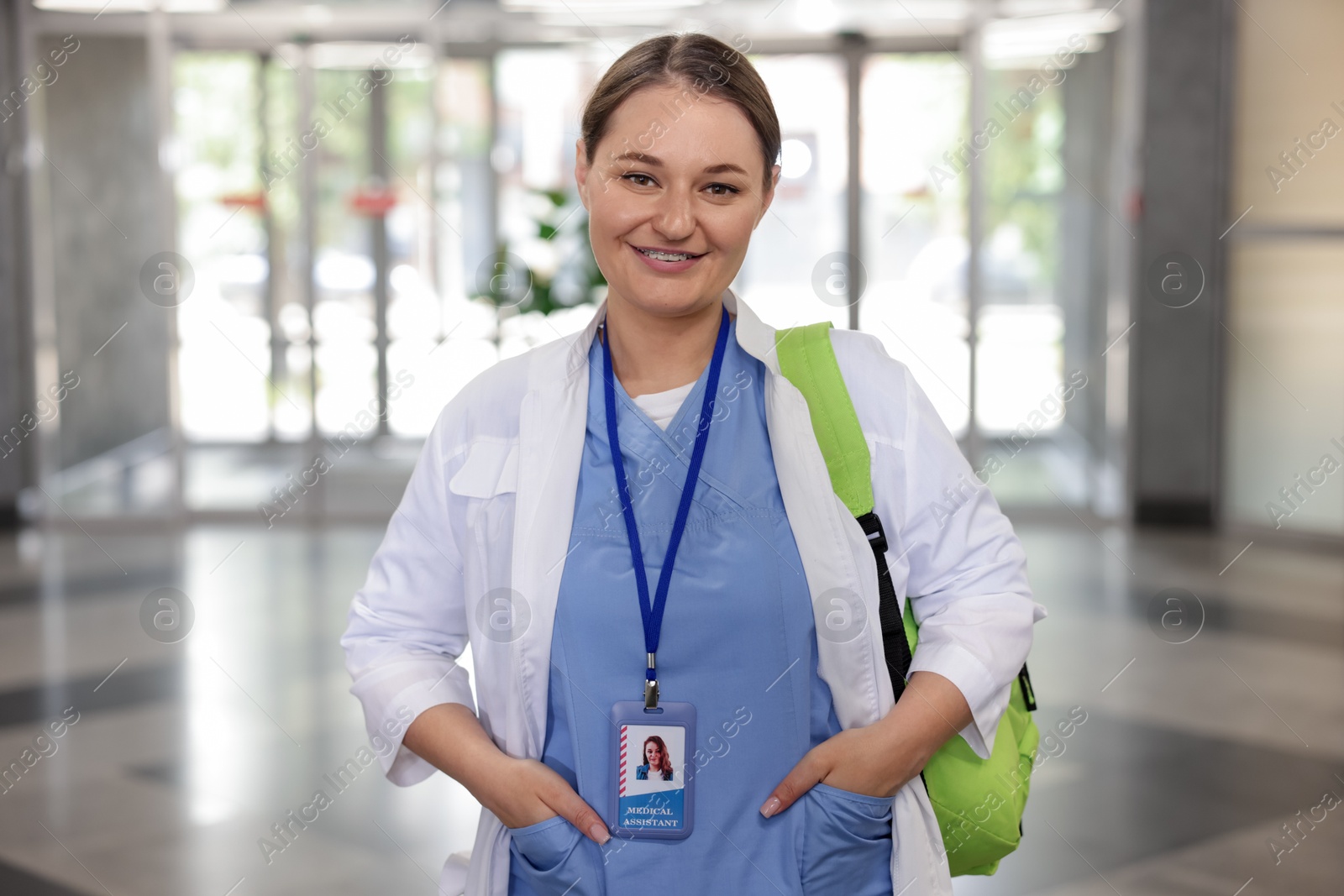 Photo of Medical student in uniform with backpack indoors