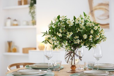 Photo of Bouquet of beautiful jasmine flowers on dining table indoors. Space for text