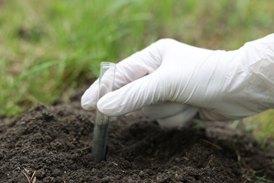 Photo of Scientist taking soil sample for research outdoors, closeup