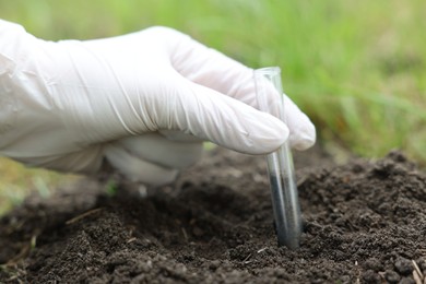 Photo of Scientist taking soil sample for research outdoors, closeup