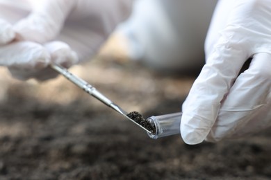 Photo of Scientist taking soil sample for research outdoors, closeup