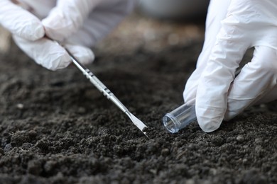 Photo of Scientist taking soil sample for research outdoors, closeup