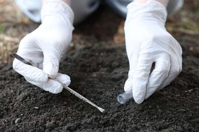 Photo of Scientist taking soil sample for research outdoors, closeup