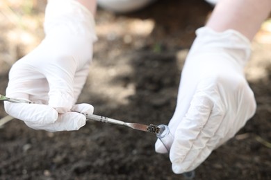 Photo of Scientist taking soil sample for research outdoors, closeup