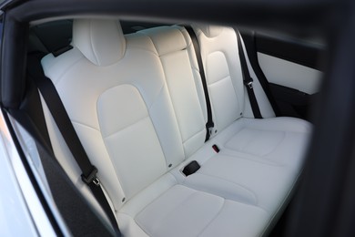 Photo of Modern car interior with seats and safety belts, view from outside