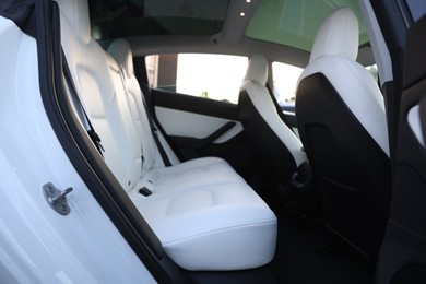 Photo of Modern car interior with seats and safety belts, view from outside