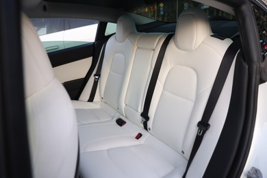 Photo of Modern car interior with seats and safety belts, view from outside