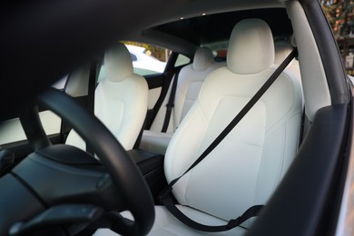 Photo of Modern car interior with seats and safety belts, view from outside