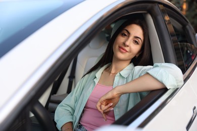 Photo of Woman sitting in modern car, view from outside