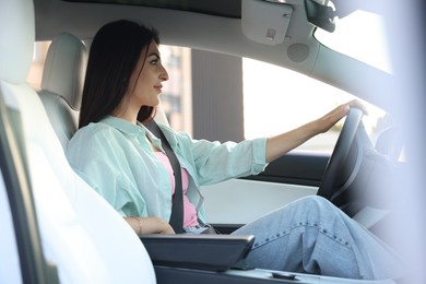 Photo of Woman holding steering wheel while driving car, view from outside