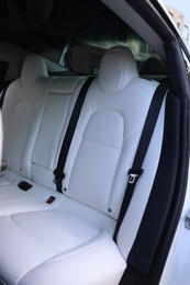 Photo of Modern car interior with seats and safety belts, view from outside
