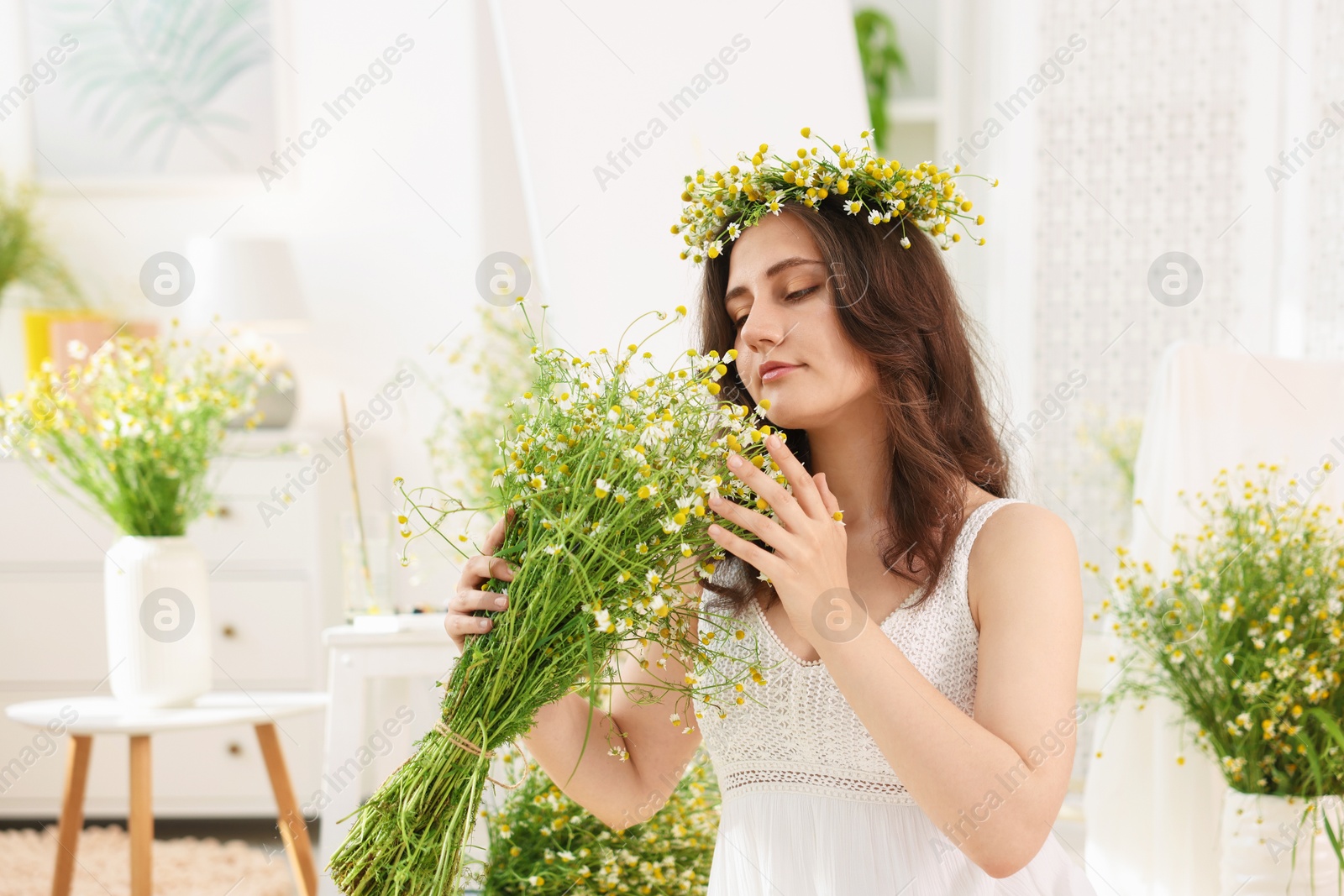 Portrait of beautiful woman with chamomile flowers indoors Photo of Portrait of beautiful woman with chamomile flowers indoors