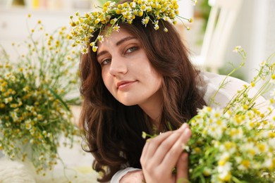Photo of Portrait of beautiful woman with chamomile flowers indoors