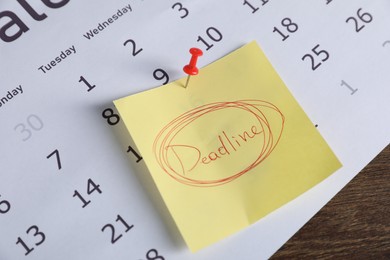 Photo of Sticky note with word Deadline and calendar on wooden table, closeup