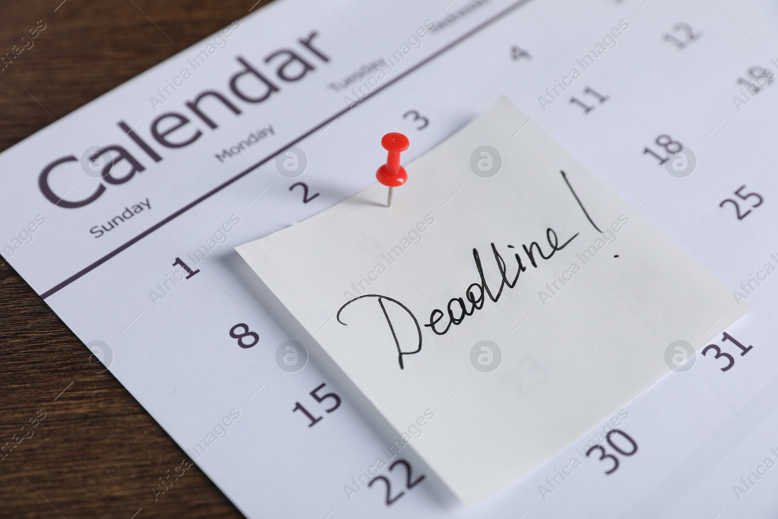 Photo of Sticky note with word Deadline and calendar on wooden table, closeup