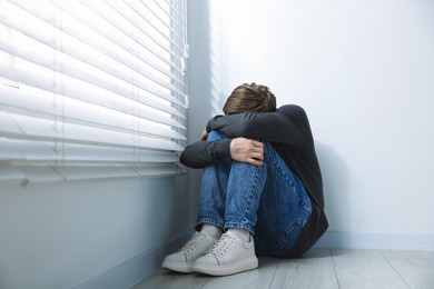 Photo of Man suffering from paranoia near window at home