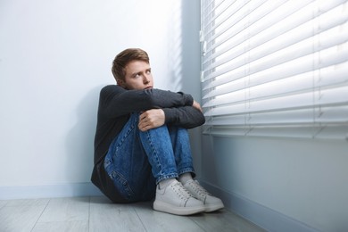 Photo of Man suffering from paranoia near window at home