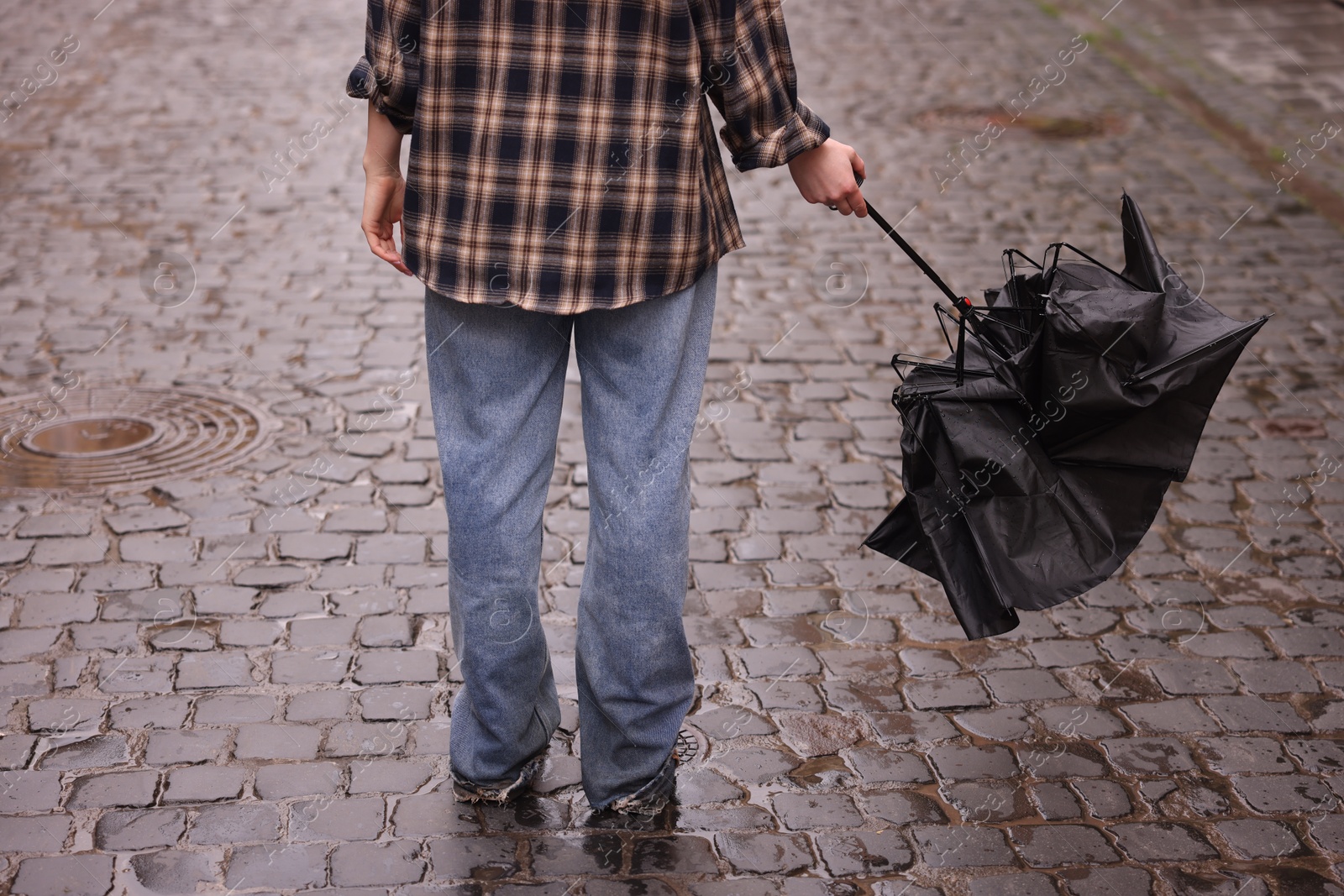 Woman with broken umbrella on wet pavement outdoors, closeup Photo of Woman with broken umbrella on wet pavement outdoors, closeup