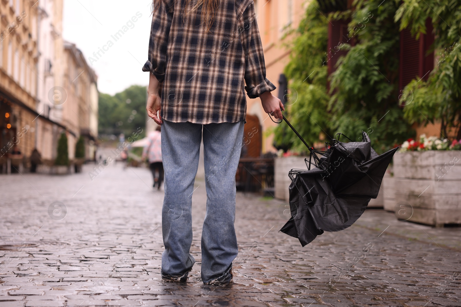 Woman with broken umbrella on wet pavement outdoors, closeup Photo of Woman with broken umbrella on wet pavement outdoors, closeup