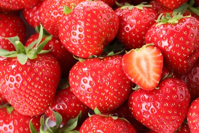 Photo of Fresh whole and cut strawberries as background, top view