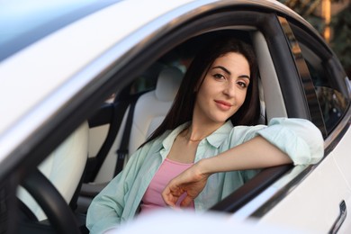 Photo of Woman sitting in modern car, view from outside