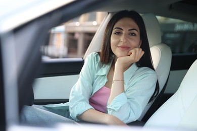 Photo of Woman sitting in modern car, view from outside