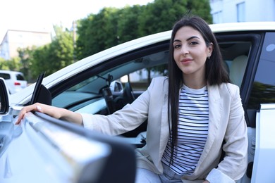 Photo of Woman getting out of modern car outdoors