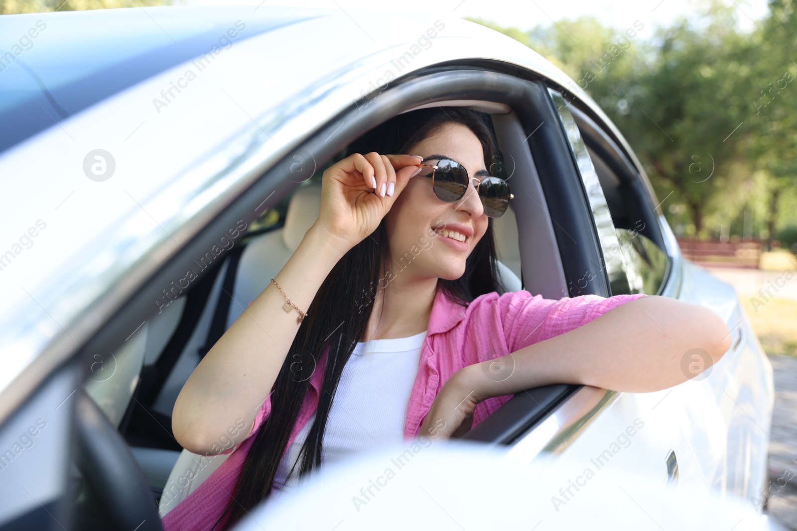 Woman behind steering wheel of modern car, view from outside Photo of Woman behind steering wheel of modern car, view from outside