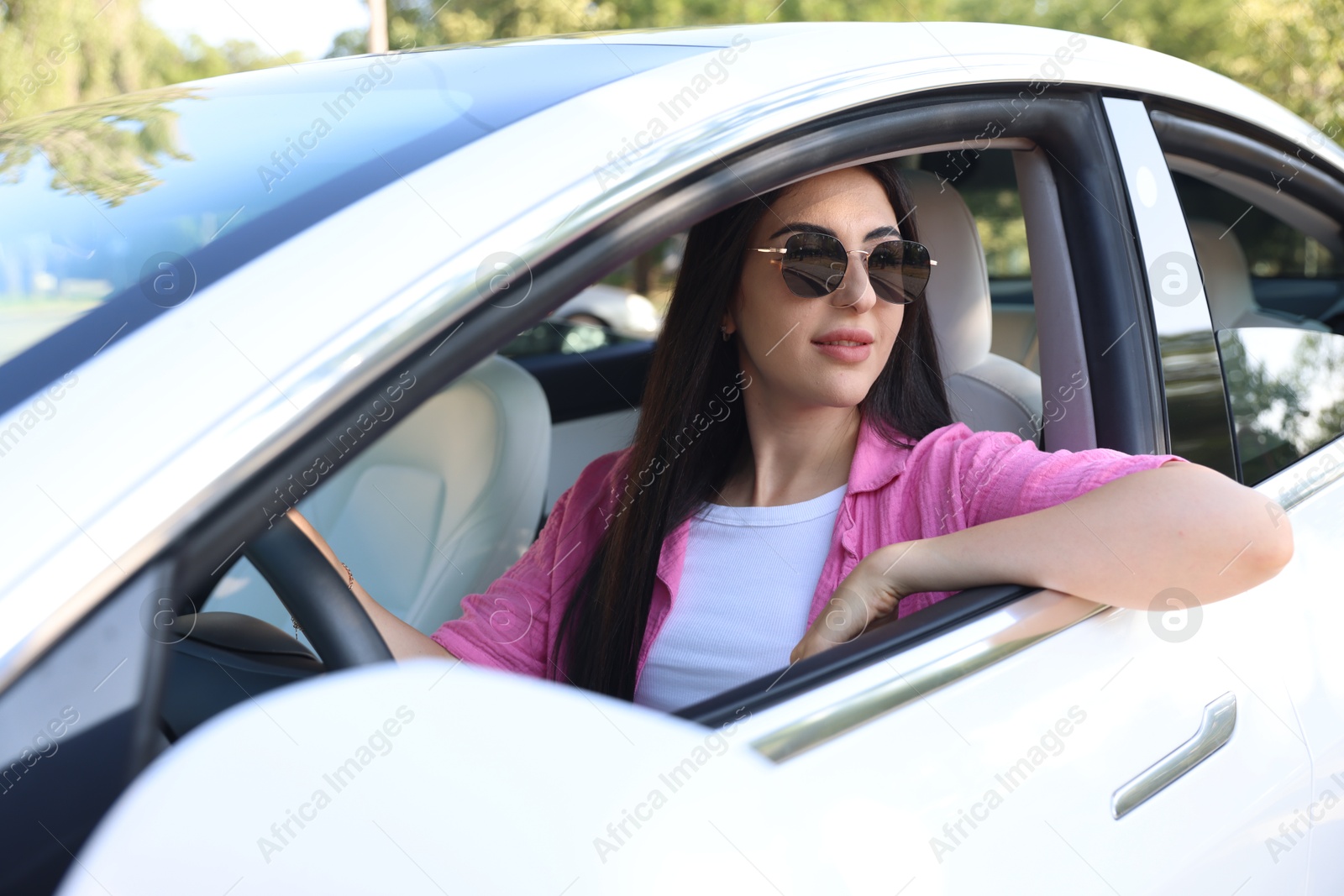 Woman behind steering wheel of modern car, view from outside Photo of Woman behind steering wheel of modern car, view from outside