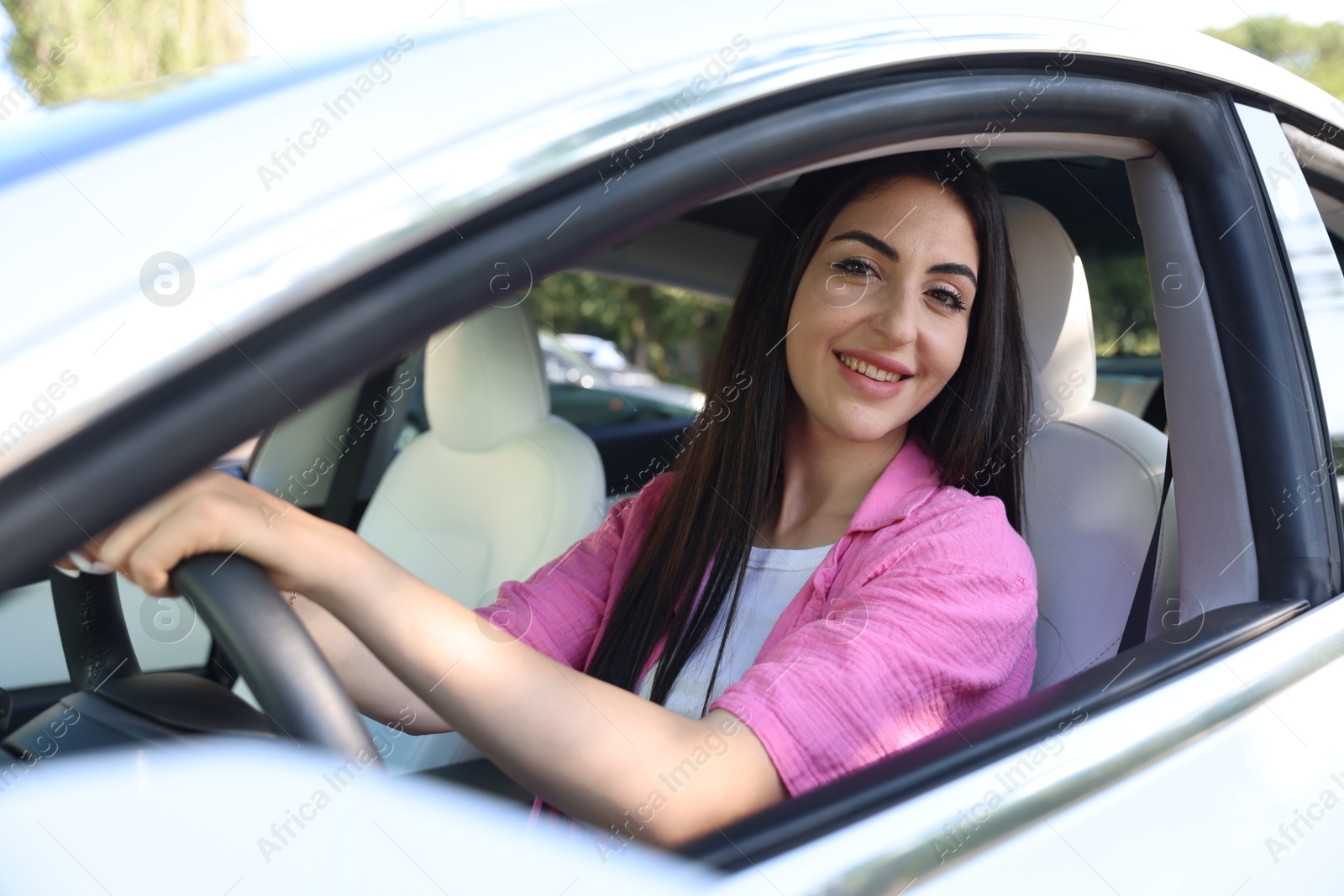 Woman behind steering wheel of modern car, view from outside Photo of Woman behind steering wheel of modern car, view from outside