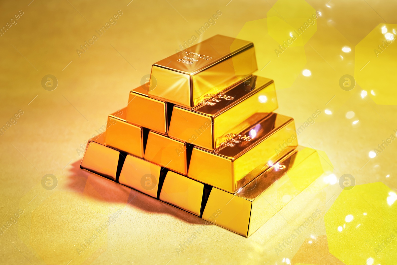 Image of Stacked shiny gold bars on color background