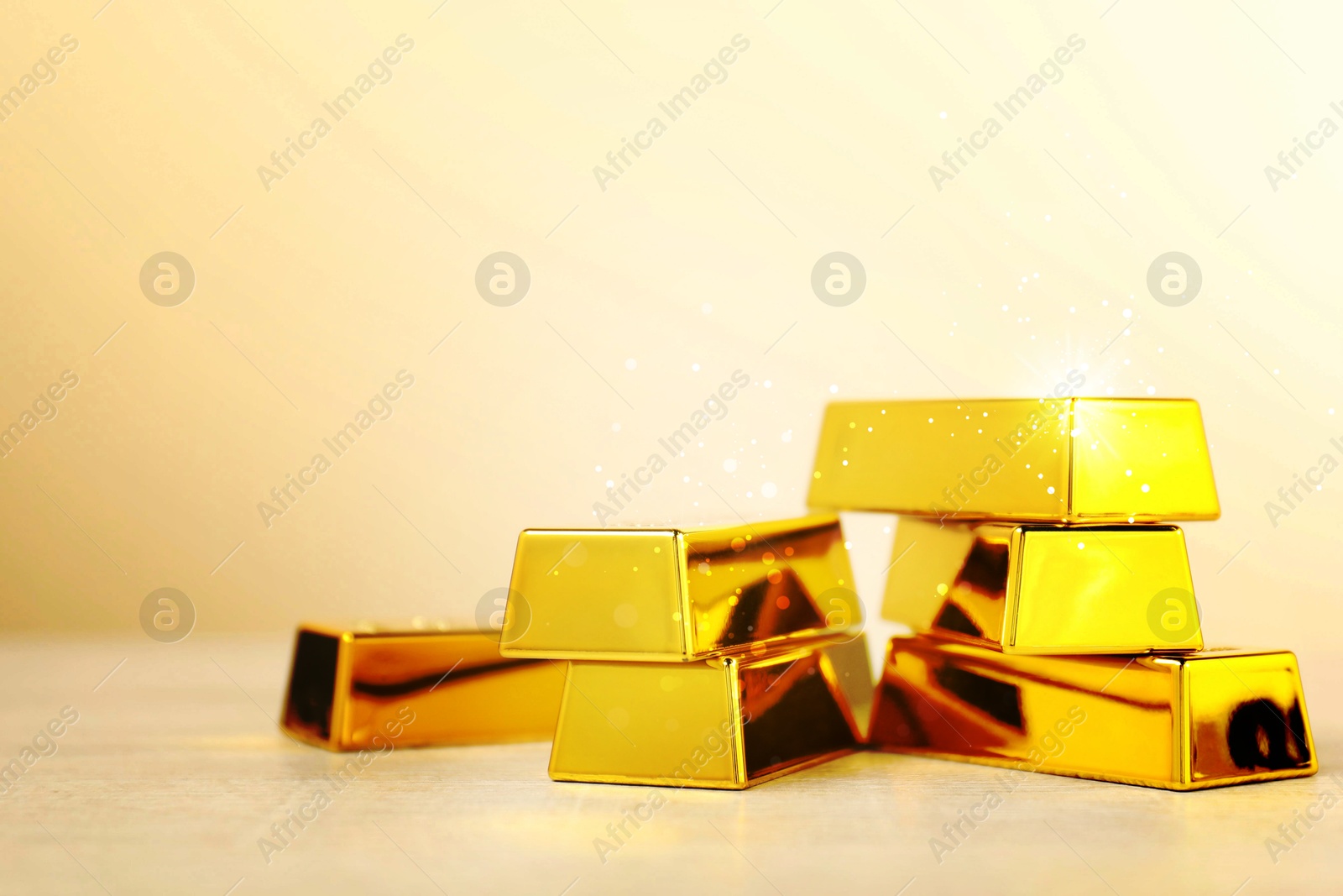 Shiny gold bars on beige background. Space for text Image of Shiny gold bars on beige background. Space for text