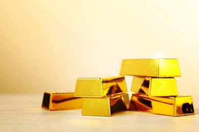 Image of Shiny gold bars on beige background. Space for text