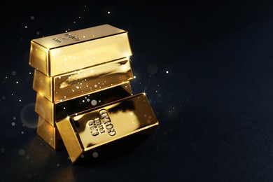 Image of Shiny gold bars on black background. Space for text