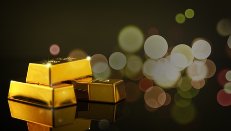 Image of Shiny gold bars on color background, bokeh effect. Banner design with space for text