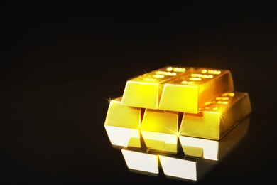 Image of Shiny gold bars on mirror surface. Space for text