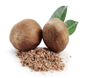 Image of Nutmeg seeds with green leaves on white background. Aromatic spice
