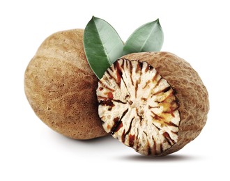 Image of Nutmeg seeds with green leaves on white background. Aromatic spice